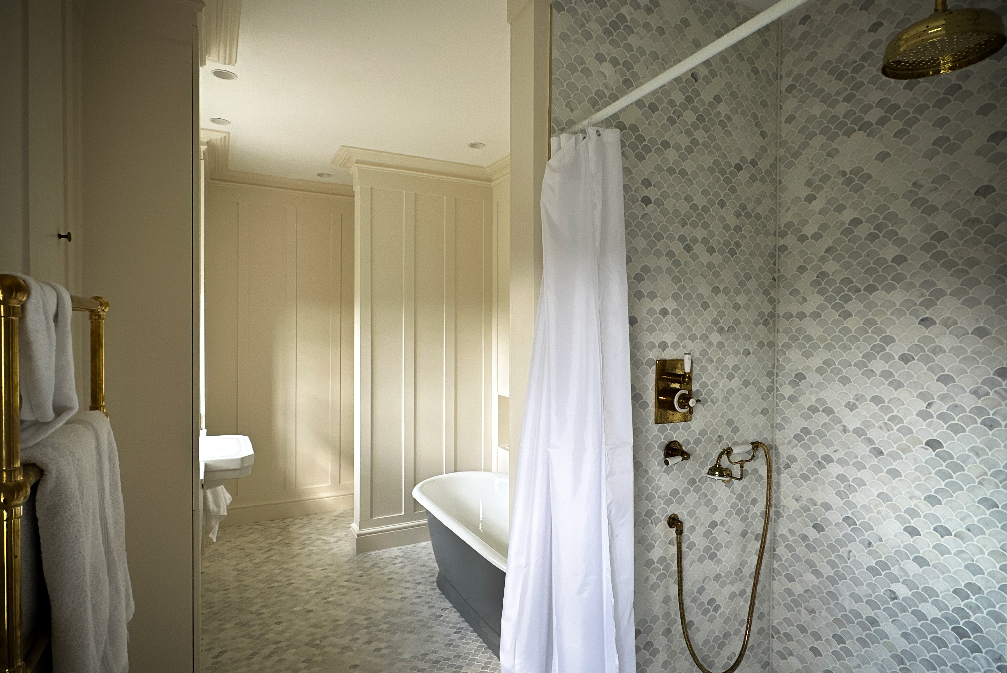 A newly renovated bathroom with a bright colour scheme, enlightened with natural light and hints of gold throughout.